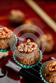 Vegan sweets, Raw food nutty sweets decorated walnut on a beautiful red violin close-up. Healthy sweets