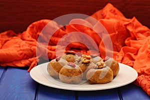 Vegan sweets with wallnuts and goji berries on orange ethnic cloth