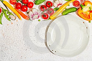 Vegan table setting. Assorted of ripe fresh vegetables, empty plate, cutlery, spices