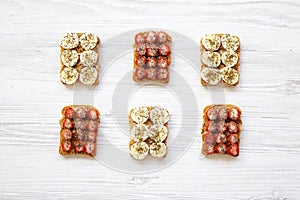 Vegan toasts with peanut butter, fruits and chia seeds over white wooden background, top view. Healthy breakfast,