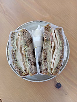 Vegan tofu sandwich wraped in paper served on saucer shot from above photo