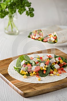 Vegan tofu wraps with pepper, corn, tomatoes and spinach