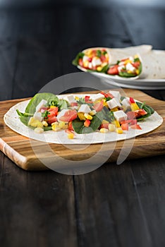 Vegan tofu wraps with pepper, corn, tomatoes and spinach