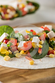 Vegan tofu wraps with pepper, corn, tomatoes and spinach