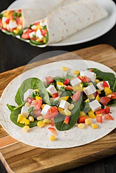 Vegan tofu wraps with pepper, corn, tomatoes and spinach