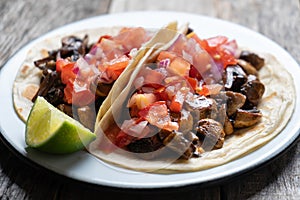 Vegan and vegetarian mexican mushrooms tacos with sauce and lime