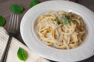 Vegan version of traditional italian pasta fettuccine alfredo with creamy white sauce garnished with basil