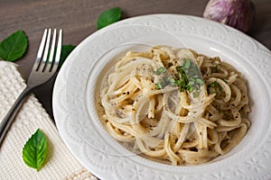 Vegan version of traditional italian pasta fettuccine alfredo with creamy white sauce garnished with basil