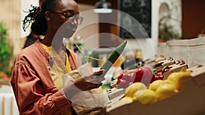 Vegan woman taking locally grown vegetables from crates