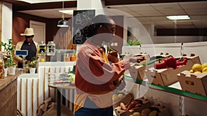 Vegan woman taking locally grown vegetables from crates