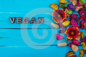 Vegan word on blue wood with flower