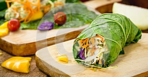 Vegan wrap made with kale or lettuce leaf, stuffed with various vegetables, healthy fast food
