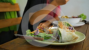 Vegan Wrap Vegetable Dish Closeup and Young Girl Enjoying delicious dinner at Vegetarian Restaurant. HD. Thailand.