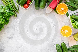 Vegearian lunch. Vegetables tomato, cucumber, asparagus, salad, orange on grey background top view copyspace