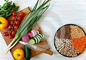Vegen food on a light background, fresh vegetables and cereals on a plate top view with place for text