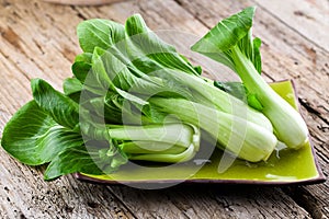 Vegetable assortment, fresh green Chinese cabbage, bok choy, pok choi or pak choi on dark background.