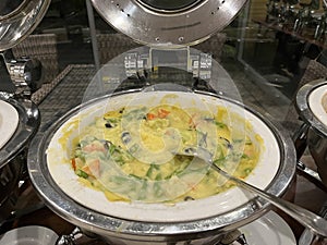 Vegetable au gratin in a chafing dish on the buffet table