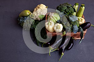 Vegetable basket. Fresh vegetables on the table black background. Set of food delivery box. Broccoli, cabbage, eggplant, white