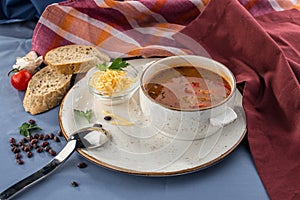 Vegetable and bean soup with cheese and bread toast on blue table