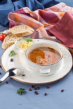 Vegetable and bean soup with cheese and bread toast on blue table