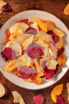 Vegetable chips, overhead shot on a wooden background