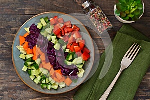 Vegetable cobs salad with stamates on a wooden background. Salad is a rainbow