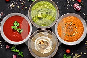 Vegetable cream soups. Top view. Black stone background