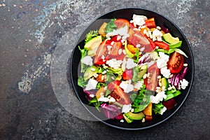 Vegetable dish, salad with avocado, pepper, tomato, italian mix, fresh lettuce, feta cheese and pine nuts. Healthy food