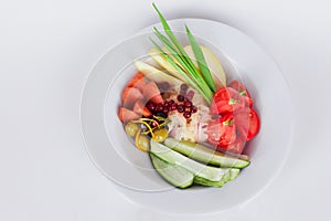Vegetable dish on top of green onions pickled tomatoes, salted cucumbers isolated white background