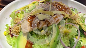 Vegetable fresh salad with boiled chicken and avocado is food healthy meal, Vegetarian diet. Closeup pouring oil on fresh salad.