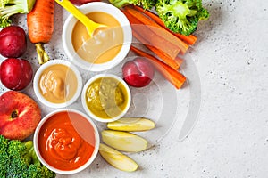 Vegetable and fruit baby puree in white bowls with ingredients, top view. Baby food concept