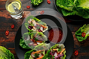 Vegetable lettuce wraps with carrot, onion, radish, red cabbage, cucumber and sweet chilli sauce