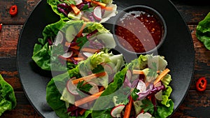 Vegetable lettuce wraps with carrot, onion, radish, red cabbage, cucumber and sweet chilli sauce