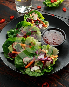 Vegetable lettuce wraps with carrot, onion, radish, red cabbage, cucumber and sweet chilli sauce