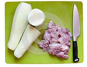 Vegetable marrows, meat, knife on a chopping board