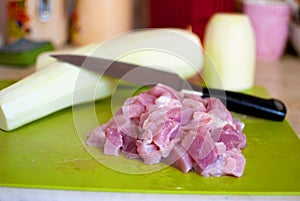 Vegetable marrows, meat, knife on a chopping board