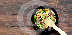 Vegetable mix in authentic pan on wooden background. Mexican food concept. Budget-friendly menu. Close-up