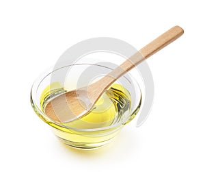 Vegetable oil and wooden spoon on a white background