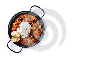 Vegetable pisto manchego with tomatoes, zucchini, peppers, onions,eggplant and egg, served in frying pan isolated on white