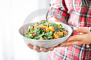 Vegetable salad bowl in woman hands