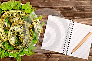 Vegetable salad with centimeter and notepad