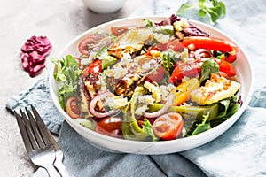 Vegetable salad cherry tomatoes, baked pepper, salad mix and onion with grilled haloumi halloumi cheese.