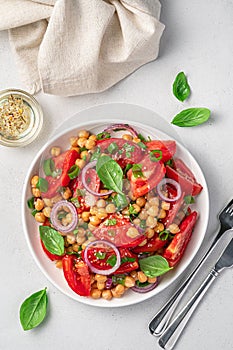 Vegetable salad with chickpeas, tomatoes, basil and olive oil. Healthy, vegetarian food.