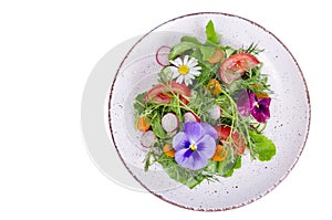 Vegetable salad with edible flowers on white background