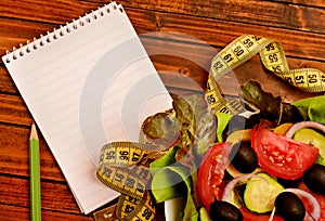 Vegetable salad with empty notebook