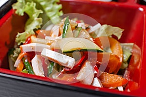 Vegetable salad. Fresh food portion in japanese bento box with salad, main course. Sushi roll with vegetables