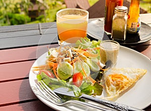 Vegetable salad with fried egg,orange juice