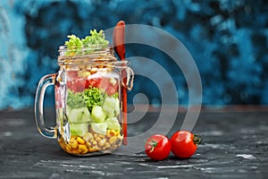 Vegetable salad in a glass jar. Spoon and cherry tomatoes. Healthy food, Diet, Detox, Clean Eating or Vegetarian concept