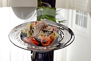 vegetable salad, lechuga with mayonnaise, sliced meat from ham and jamon, beautifully decorated with chopped vegetables on a plate photo