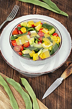 Vegetable salad with runner beans on a wooden surface